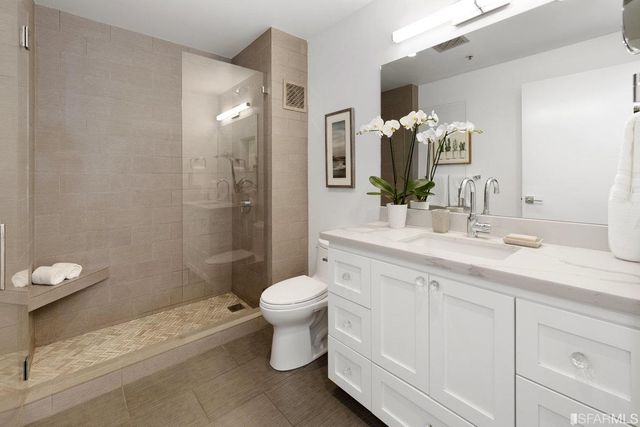 a bathroom with a double vanity sink toilet and shower