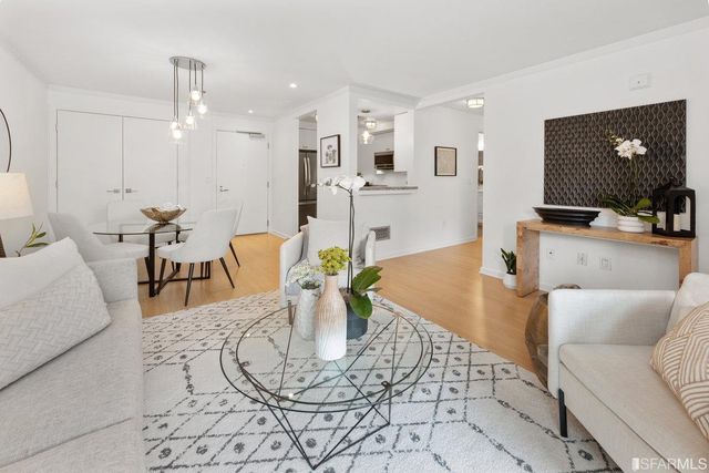 a living room with furniture kitchen view and a flat screen tv