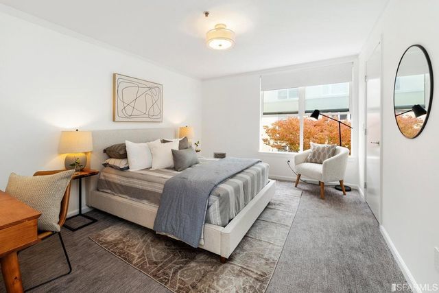 a bed room with a bed and a painting on the wall