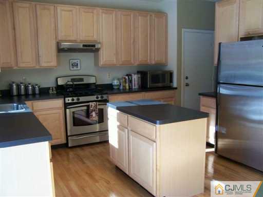 75 Stratton Road Old Bridge, NJ 07747 - Photo 5 of 8 a kitchen with a stove and a refrigerator
