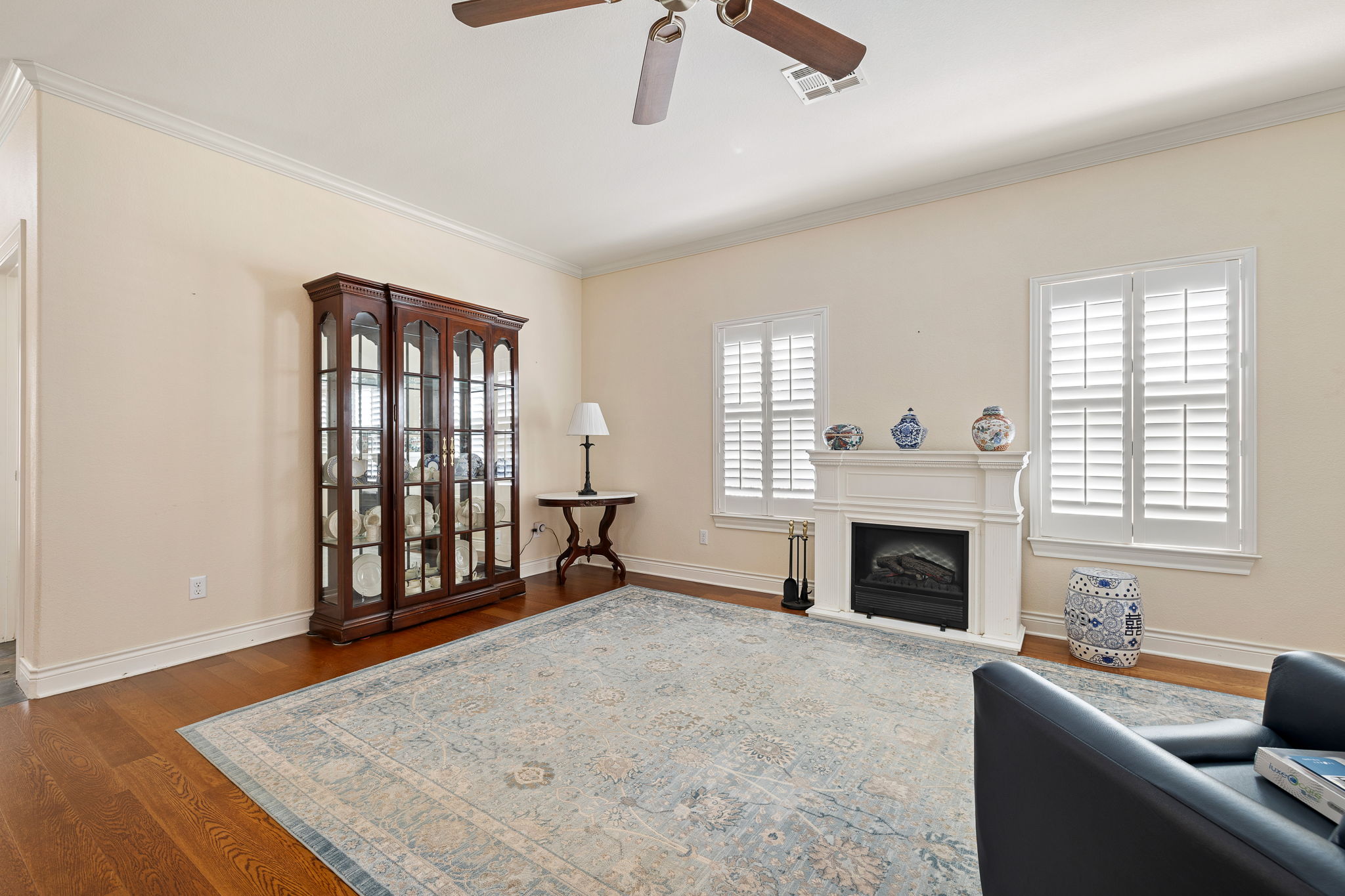 5201 Big Spring Street Georgetown, TX 78633 - Photo 6 of 26 Living area with ornamental molding, a fireplace with raised hearth, dark wood finished floors, and ceiling fan