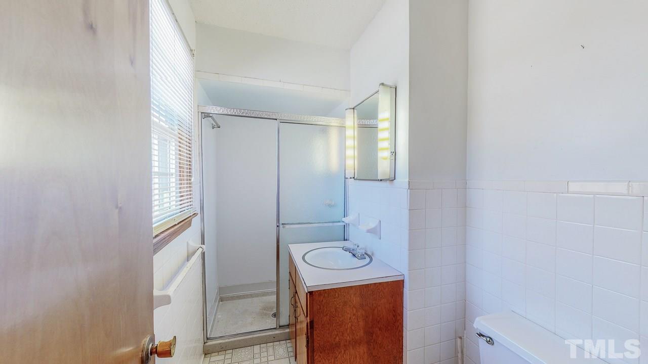 122 Henderson Road Roxboro, NC 27573 - Photo 17 of 27 a bathroom with a granite countertop toilet sink and mirror