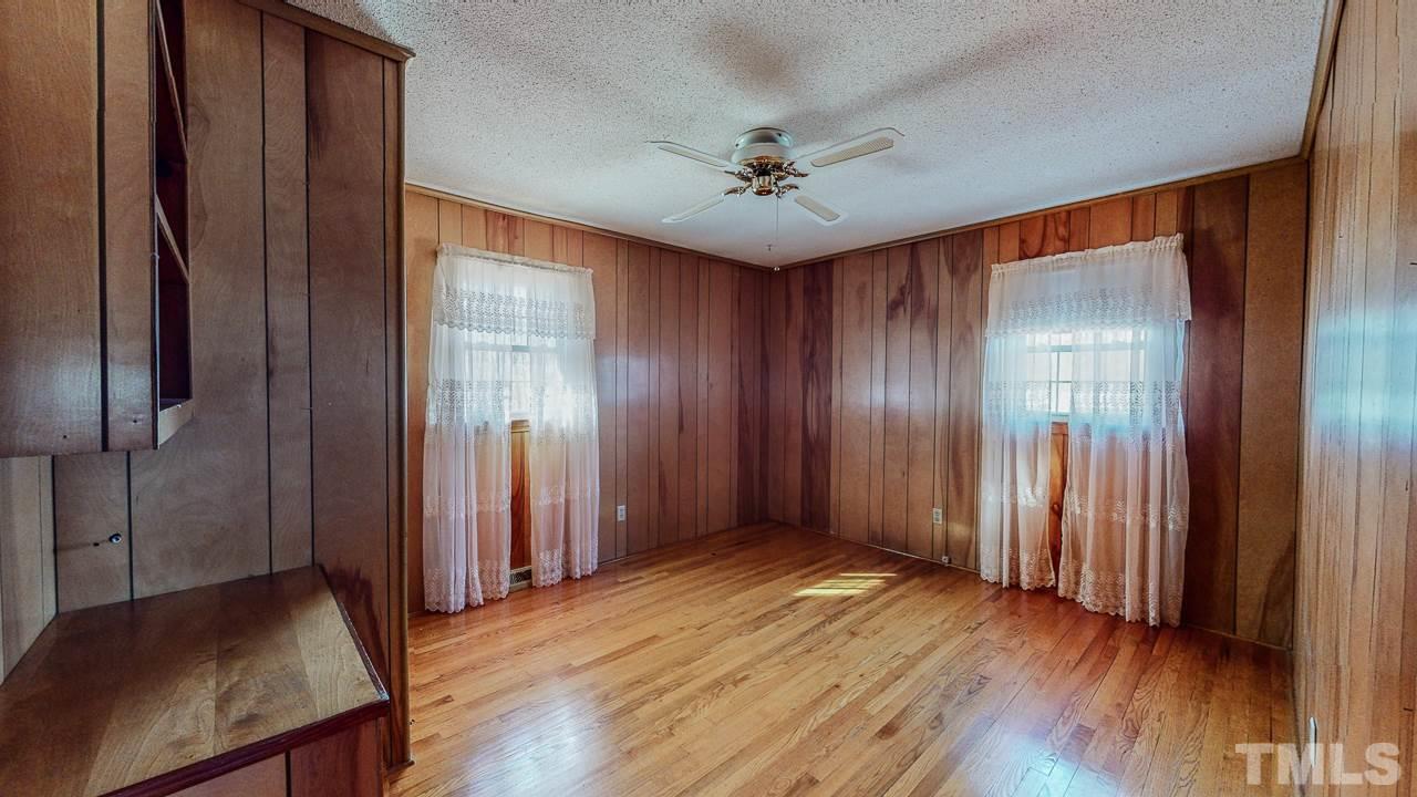 122 Henderson Road Roxboro, NC 27573 - Photo 18 of 27 an empty room with wooden floor and a chandelier fan