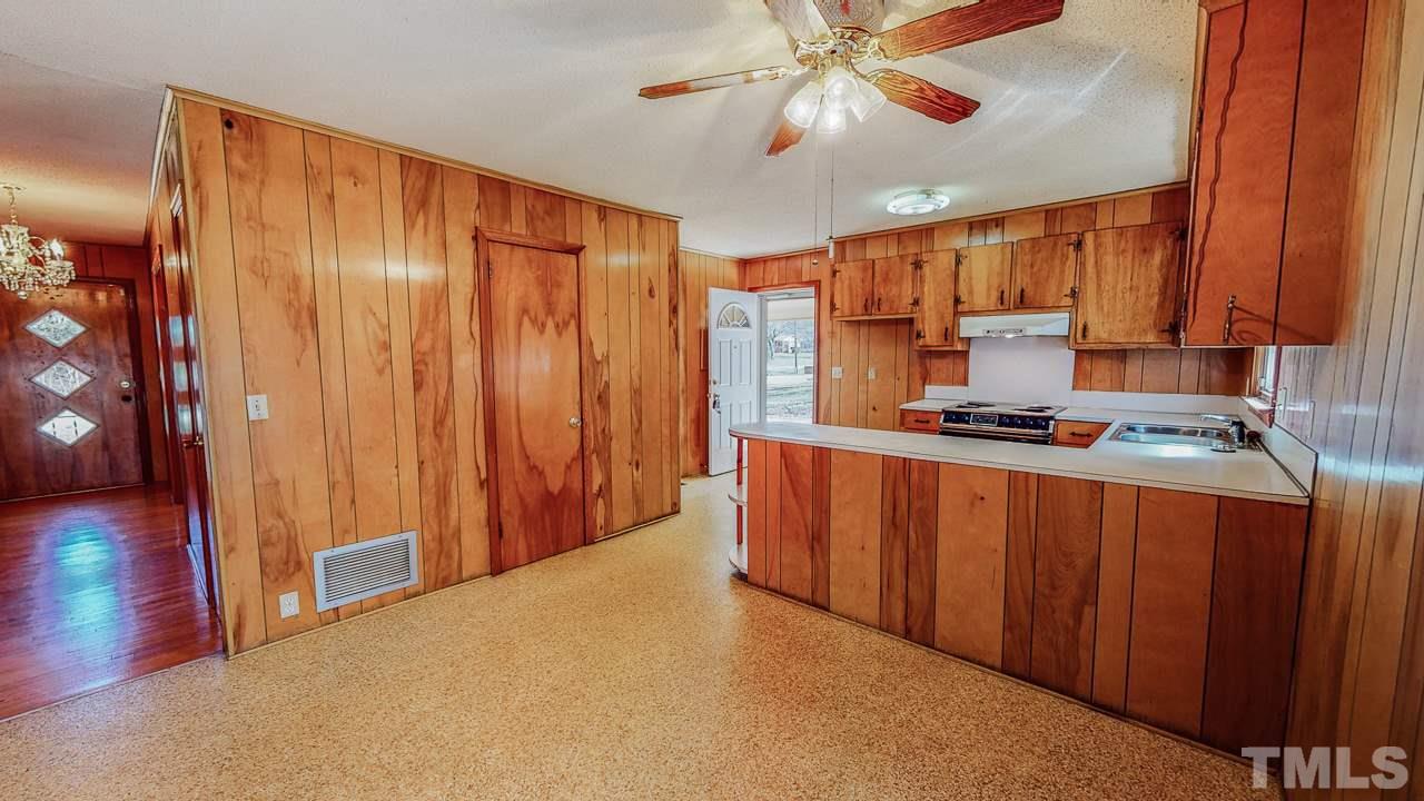 122 Henderson Road Roxboro, NC 27573 - Photo 5 of 27 a kitchen with stainless steel appliances granite countertop a refrigerator a sink and wooden cabinets