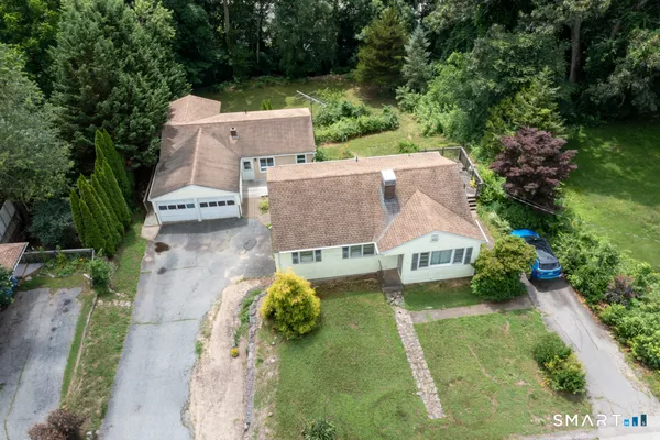 an aerial view of a house with a garden and lake view