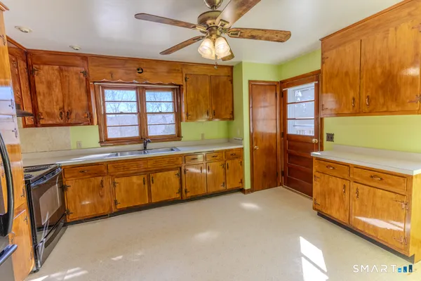 a large kitchen with stainless steel appliances granite countertop a sink and a cabinets