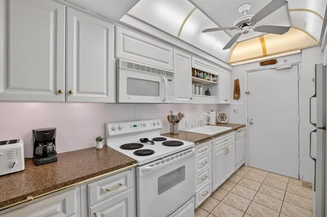 a kitchen with stainless steel appliances granite countertop a sink a stove and cabinets