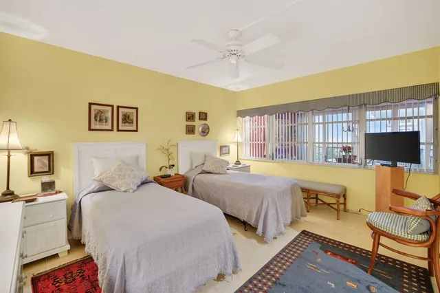 a spacious bedroom with two beds and a flat screen tv