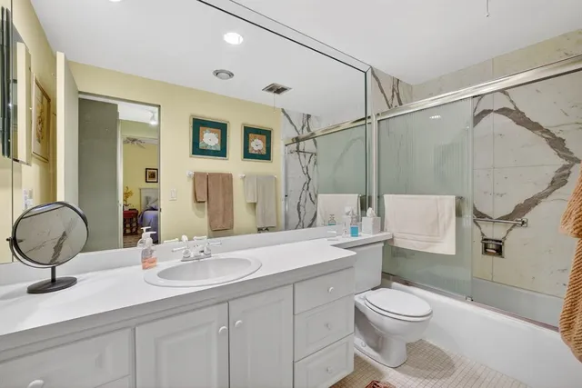 a bathroom with a double vanity sink toilet mirror and shower