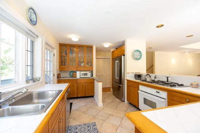 a large kitchen with a large window and stainless steel appliances