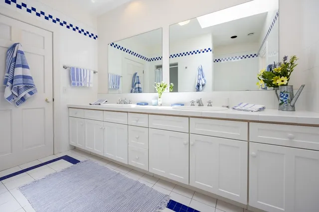a spacious bathroom with a double vanity sink mirror and next to a window