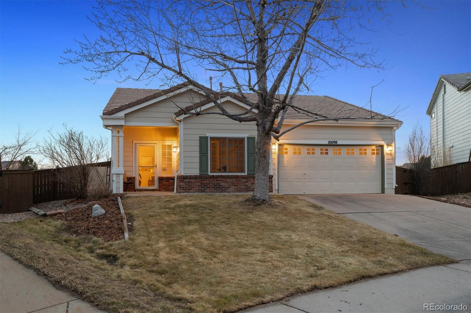 a view of a house with a tree and wooden fence