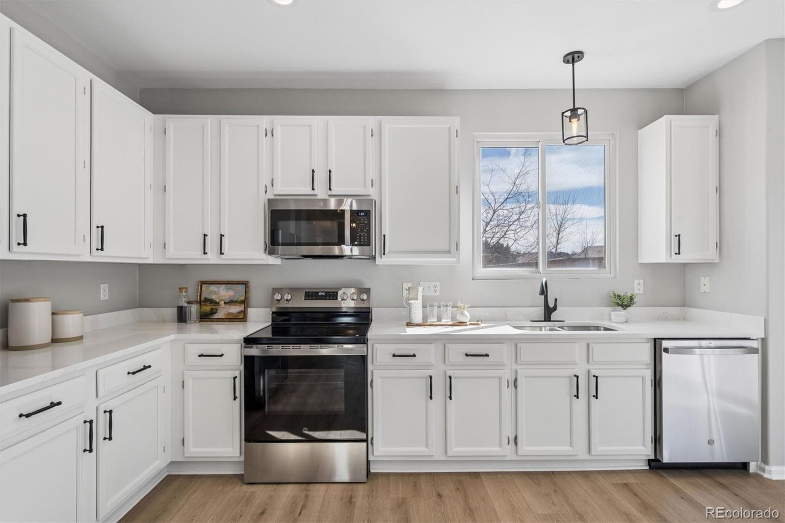10098 MacKay Drive Highlands Ranch, CO 80130 - Photo 14 of 42 a kitchen with white cabinets appliances and sink