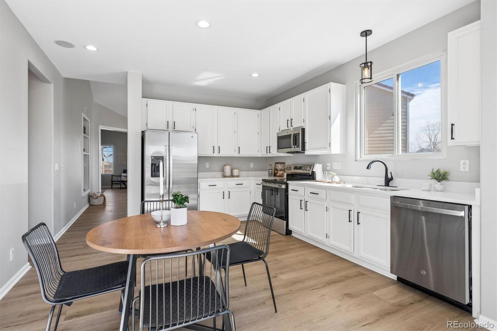 10098 MacKay Drive Highlands Ranch, CO 80130 - Photo 16 of 42 a kitchen with stainless steel appliances kitchen island a table chairs sink and cabinets