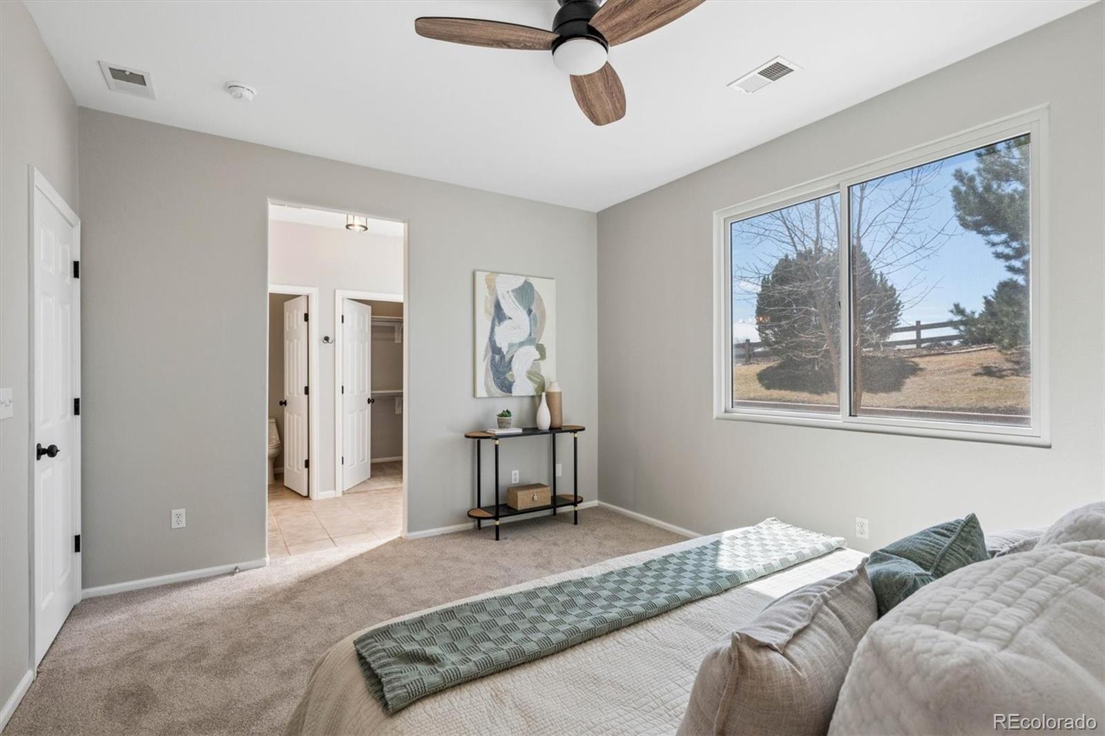 10098 MacKay Drive Highlands Ranch, CO 80130 - Photo 18 of 42 a bedroom with a bed a window and glass door