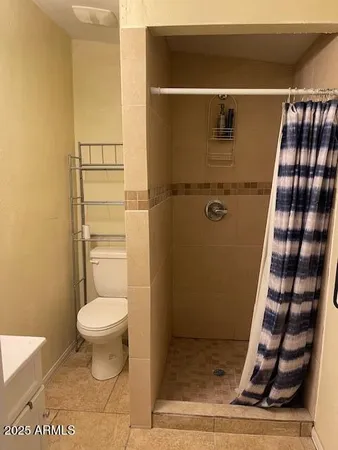 a bathroom with a toilet and a shower