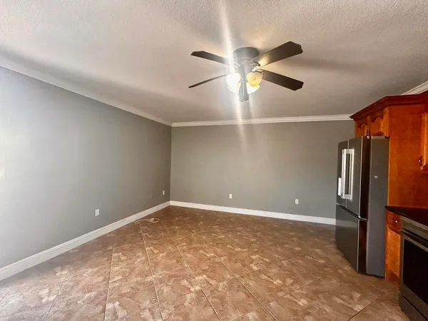 an empty room with windows and fan