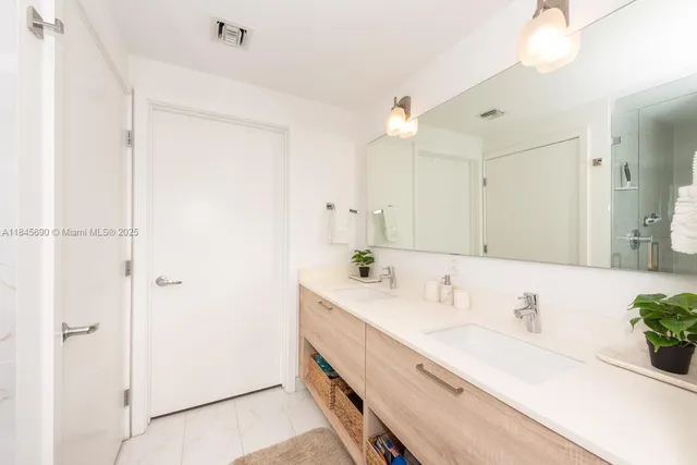 a bathroom with a double vanity sink mirror and