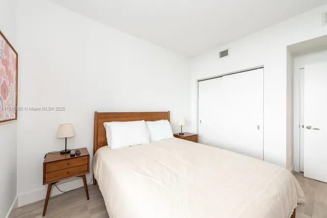 a bedroom with a bed and a lamp on table