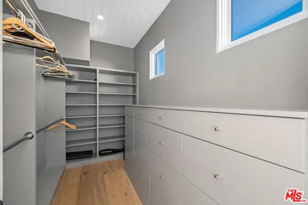 a view of walk in closet with empty racks
