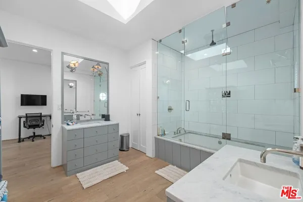a spacious bathroom with a tub sink shower and mirror