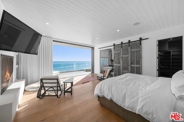 a spacious bedroom with a bed and large windows
