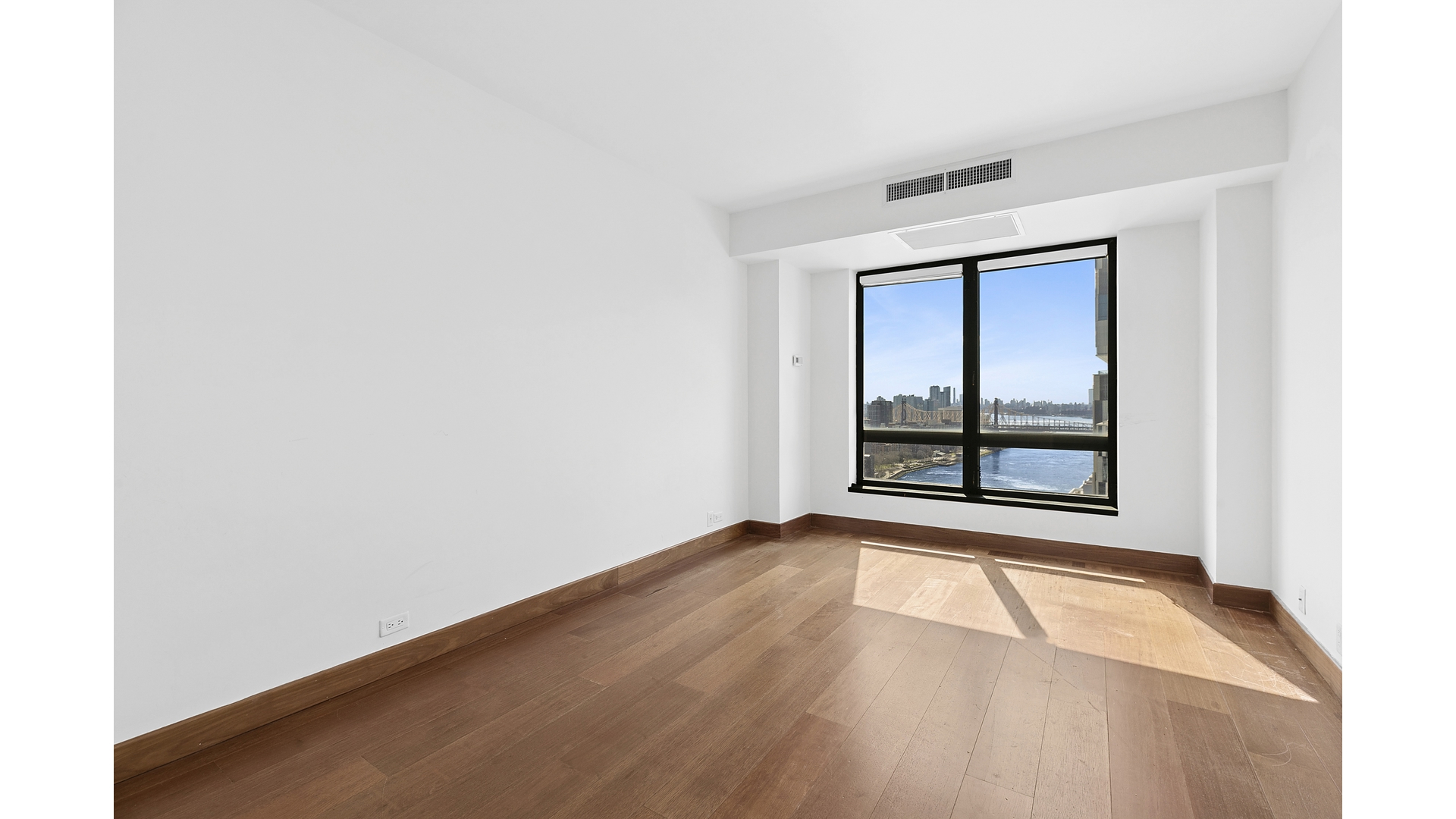 530 East 76th Street, Unit 33H Manhattan, NY 10021 - Photo 8 of 10 an empty room with wooden floor and windows