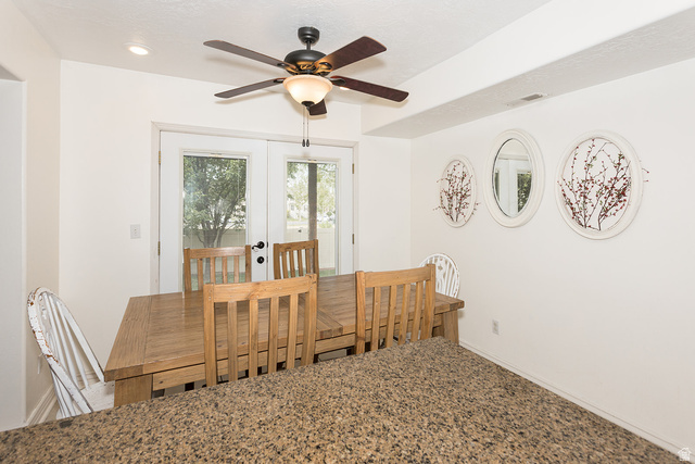 7797 North Windhover Road Eagle Mountain, UT 84005 - Photo 12 of 33 Dining area featuring double French doors, a ceiling fan with integrated lighting, recessed ceiling lighting, and a textured countertop peninsula