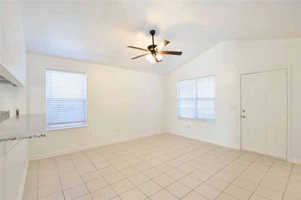 an empty room with windows and fan