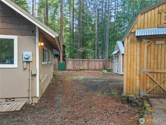a view of a house with backyard and wooden fence