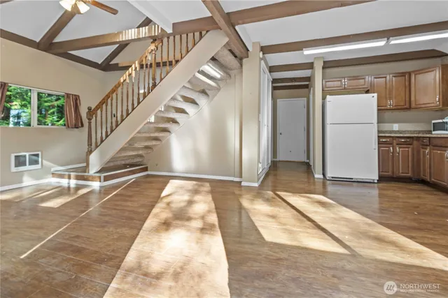 a view of a hallway with wooden floor and staircase