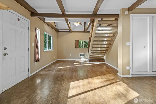 a view of a hallway with wooden floor and entryway