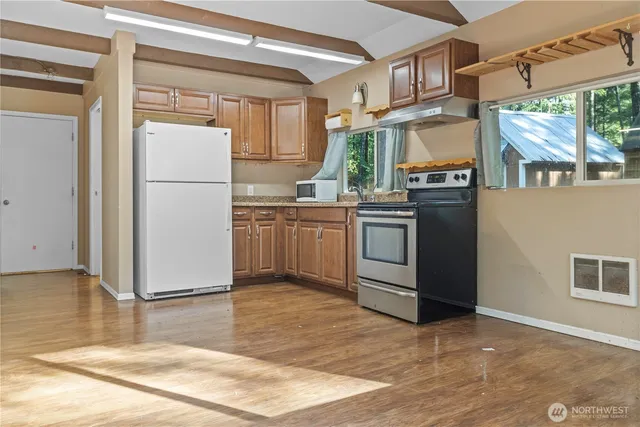 a kitchen with stainless steel appliances granite countertop a refrigerator a stove a sink and a microwave