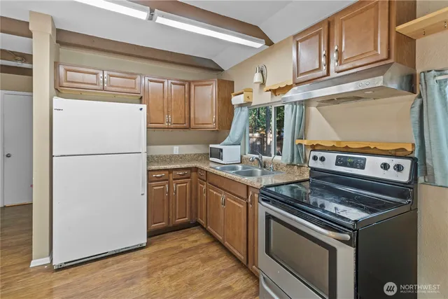 a kitchen with stainless steel appliances granite countertop a refrigerator stove and sink