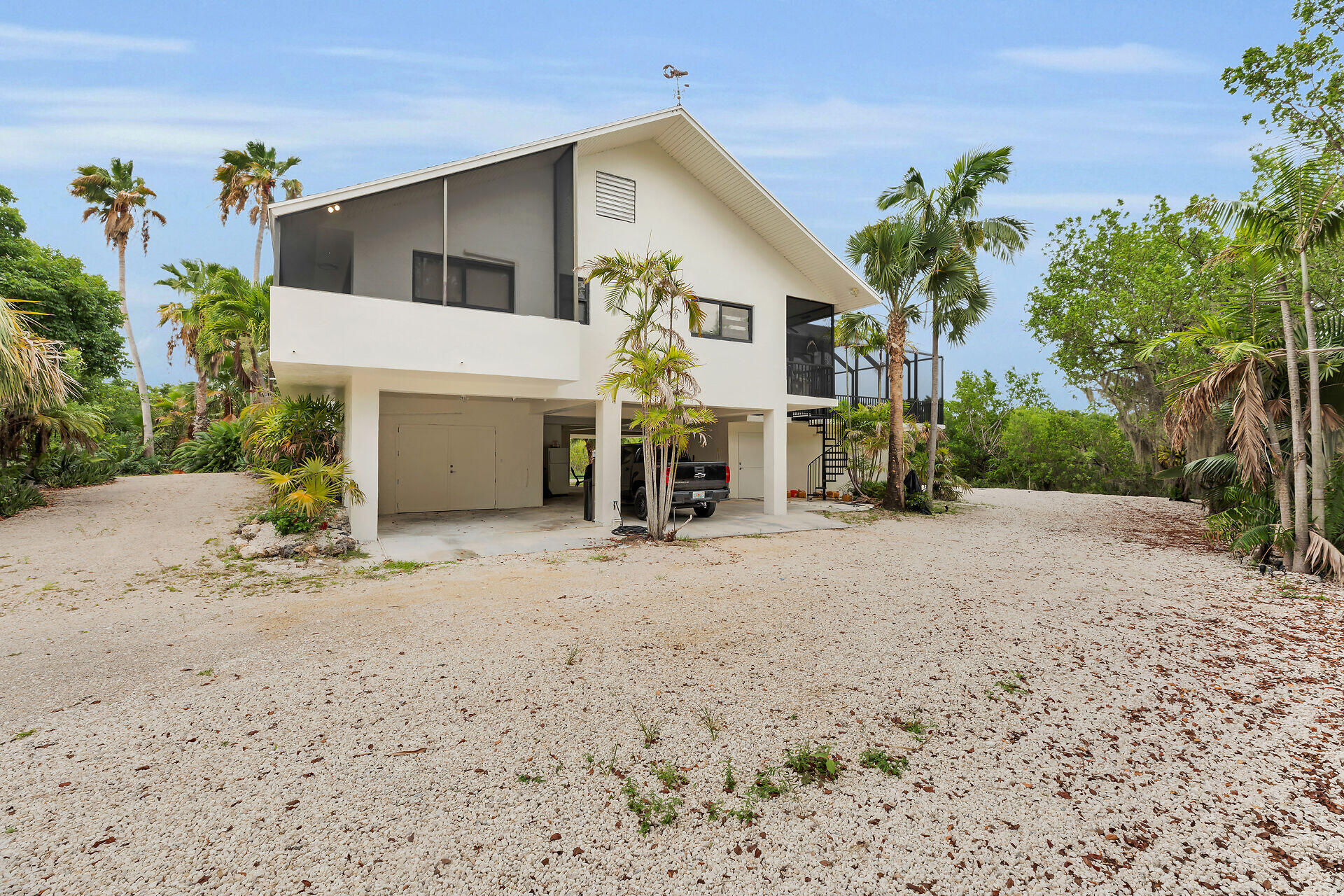 31 South Carysfort Circle Key Largo, FL 33037 - Photo 10 of 47 a front view of a house with a yard and garage