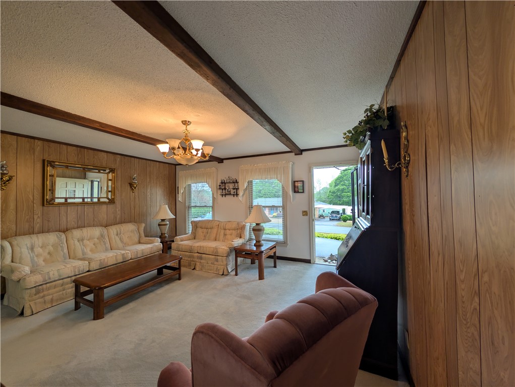 1000 Hickory Lane Anderson, SC 29624 - Photo 6 of 37 This living room features elegant chandeliers and durable carpet flooring, perfect for comfortable living.