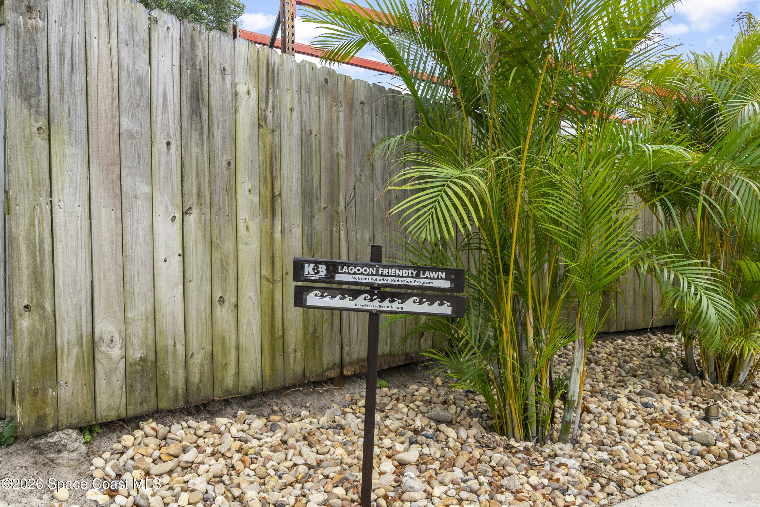 1981 Guava Avenue, Unit 104 Melbourne, FL 32935 - Photo 14 of 20 a view of a backyard with a wooden fence
