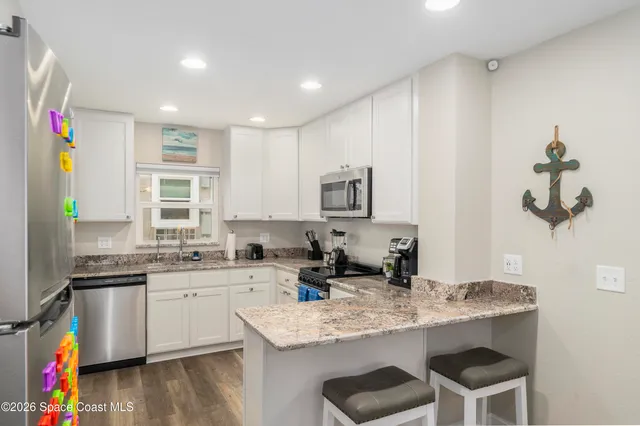 a kitchen with a sink cabinets and wooden floor