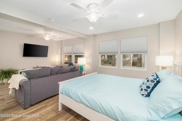a bedroom with a bed a couch and a window