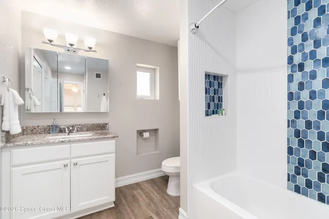 a bathroom with a sink a toilet a mirror and shower