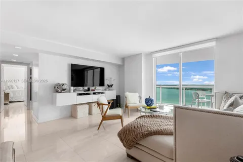 a living room with furniture a flat screen tv and a large window