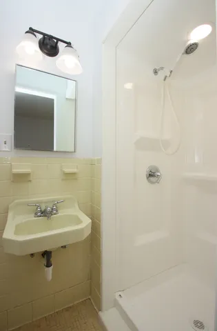 a bathroom with a sink a shower and a mirror