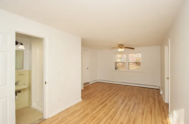 an empty room with wooden floor and windows