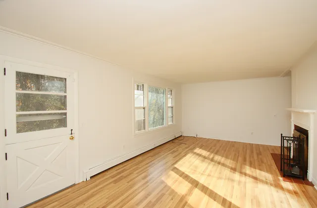 a view of a bedroom with wooden floor and windows