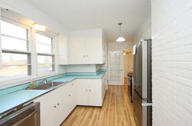 a large kitchen with a large window appliances and cabinets
