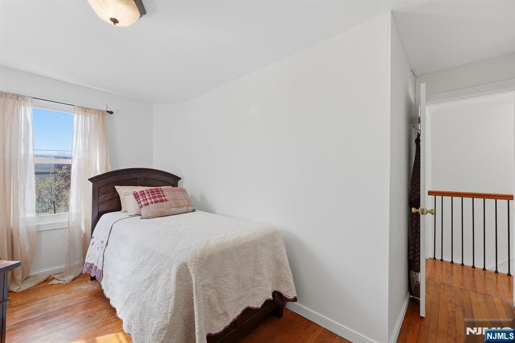 385 Berkeley Avenue Bloomfield, NJ 07003 - Photo 19 of 39 a bedroom with a bed and wooden floor