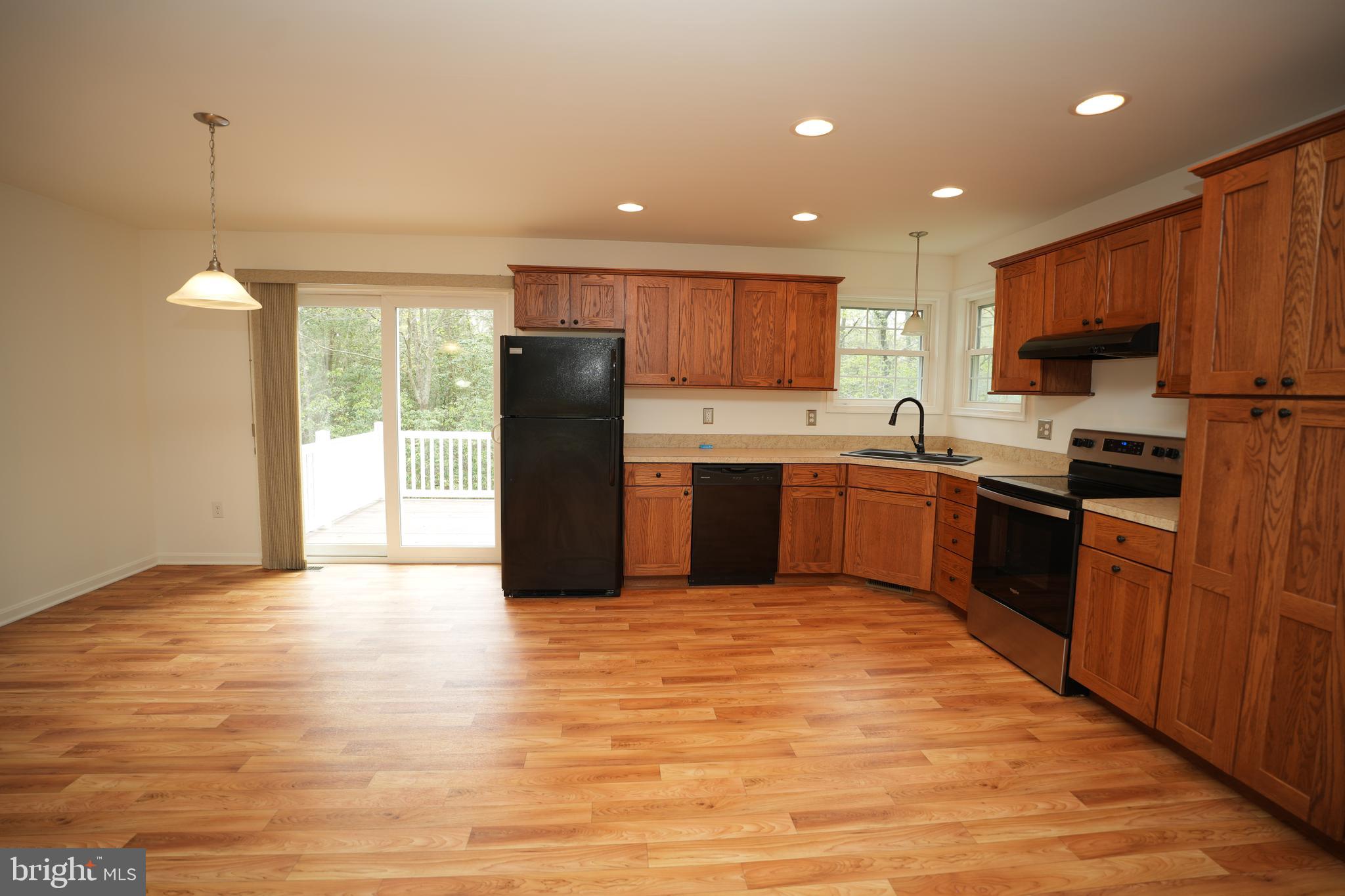 18871 Three Notch Road Lexington Park, MD 20653 - Photo 14 of 34 a kitchen with stainless steel appliances granite countertop a refrigerator a sink dishwasher and a stove with wooden floor