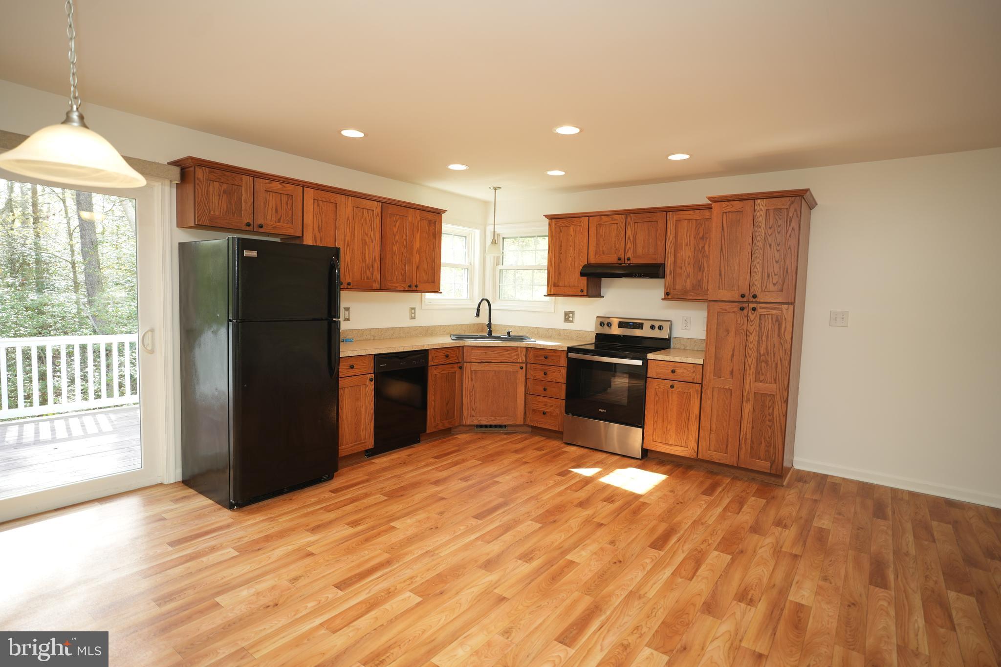 18871 Three Notch Road Lexington Park, MD 20653 - Photo 15 of 34 a kitchen with a refrigerator a stove top oven a sink and dishwasher with wooden floor