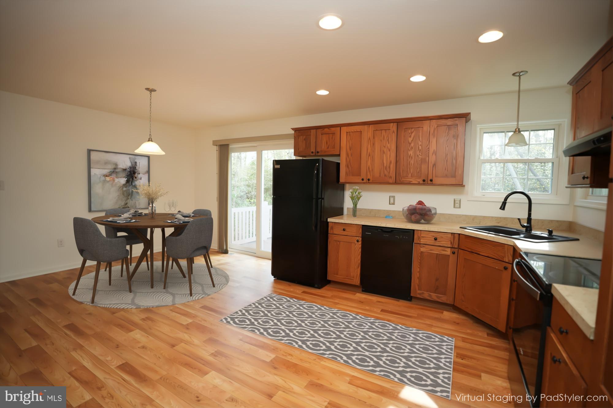 18871 Three Notch Road Lexington Park, MD 20653 - Photo 4 of 34 a kitchen with a table chairs refrigerator and dining table