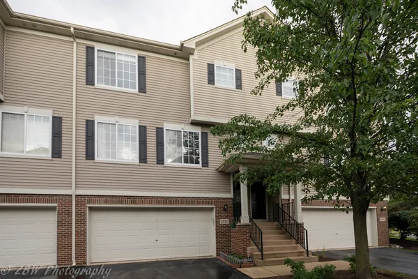a front view of a house with a tree